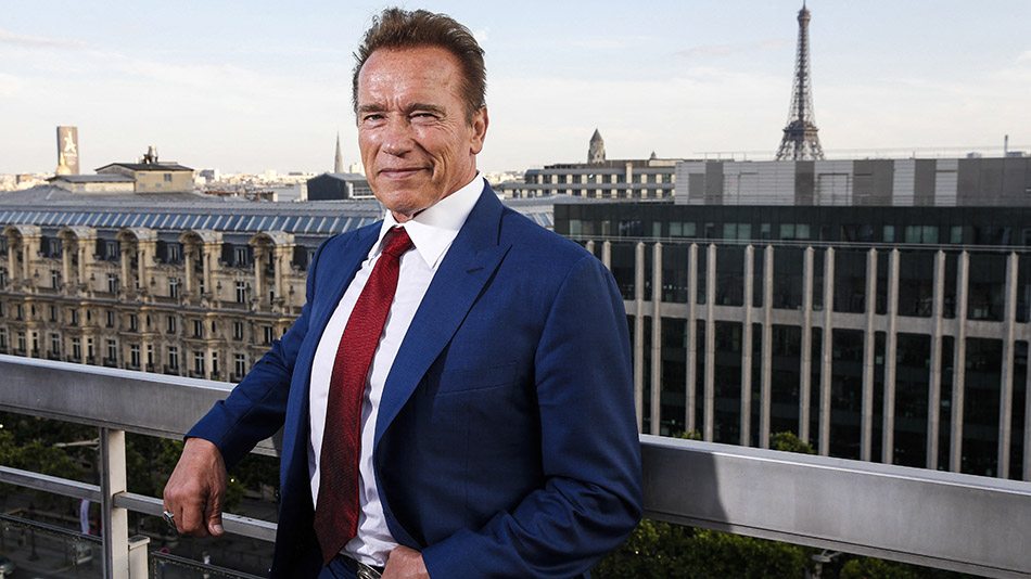 Arnold Schwarzenegger egy irodaház tetején, öltönybeny