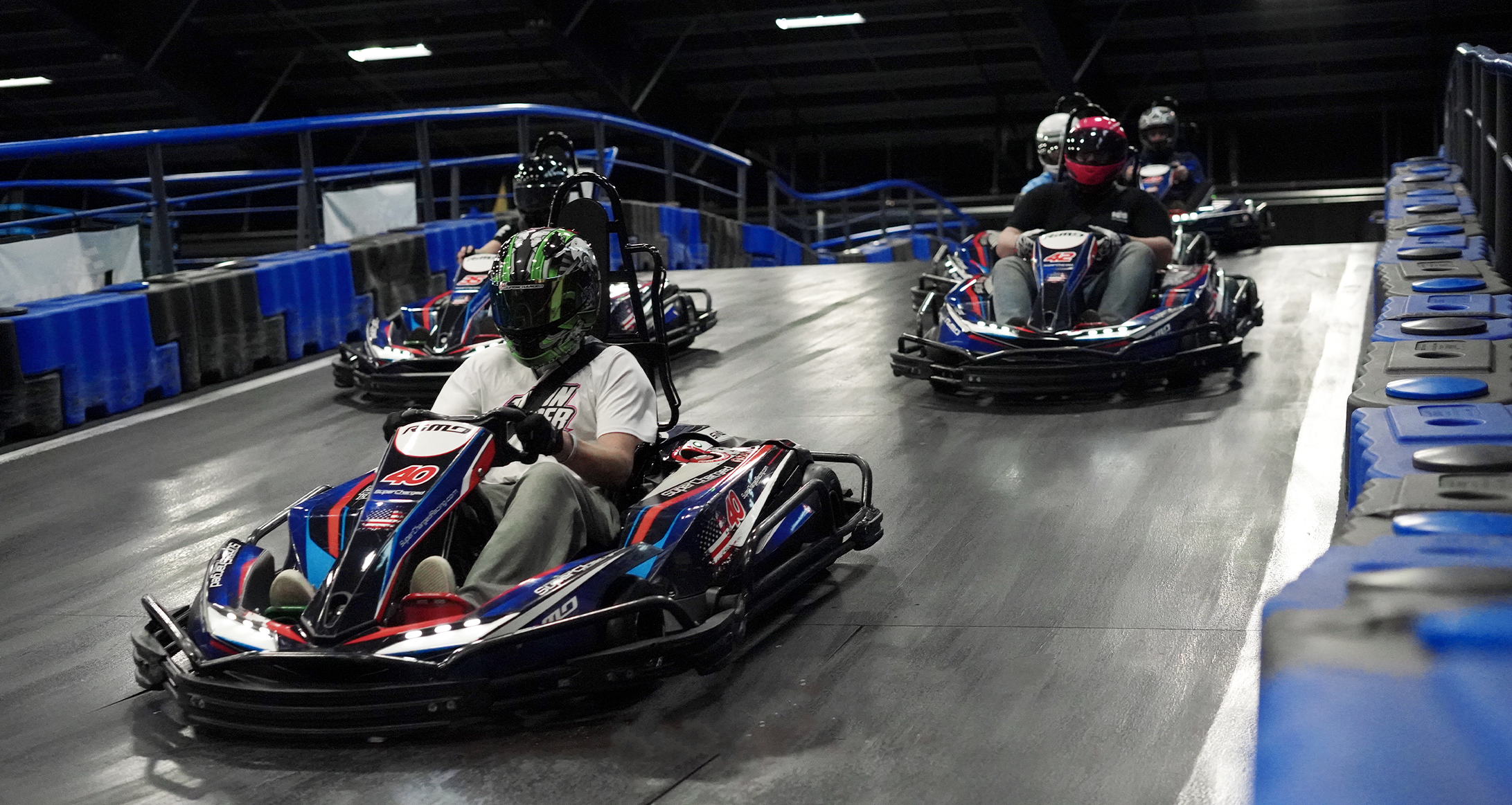 3 ember versenyez a gokart pályán közel egymáshoz