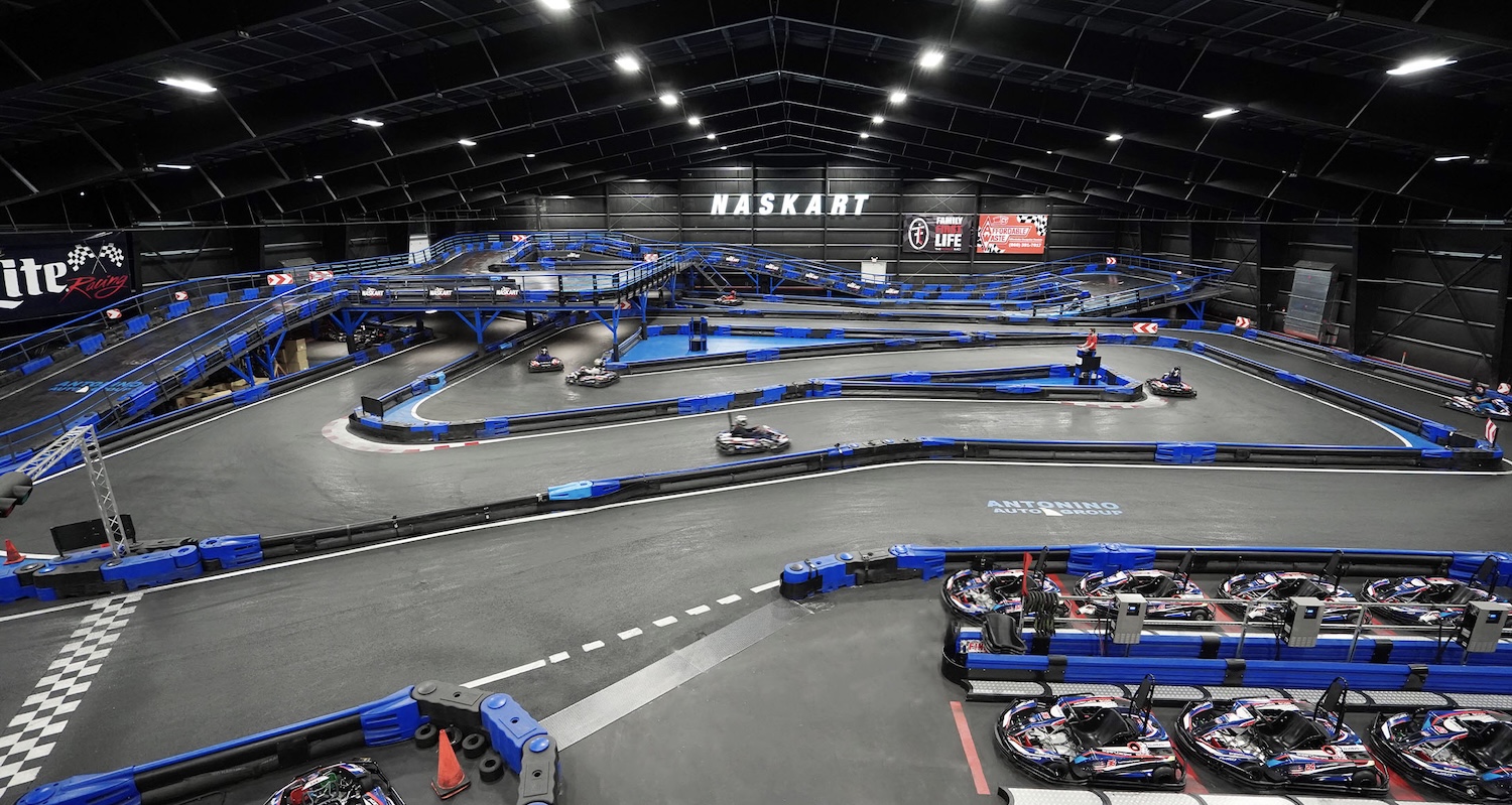 Felülnézeti kép a gokart pályáról, kanyargós nyomvonallal és versenyzőkkel