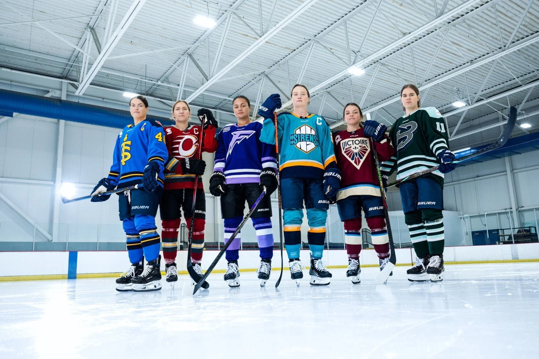 PWHL team jerseys lined up on display.