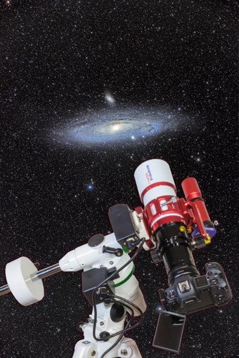 An image of a professional astronomical telescope pointed towards space, capturing a photo of a very bright and detailed galaxy on the night sky.