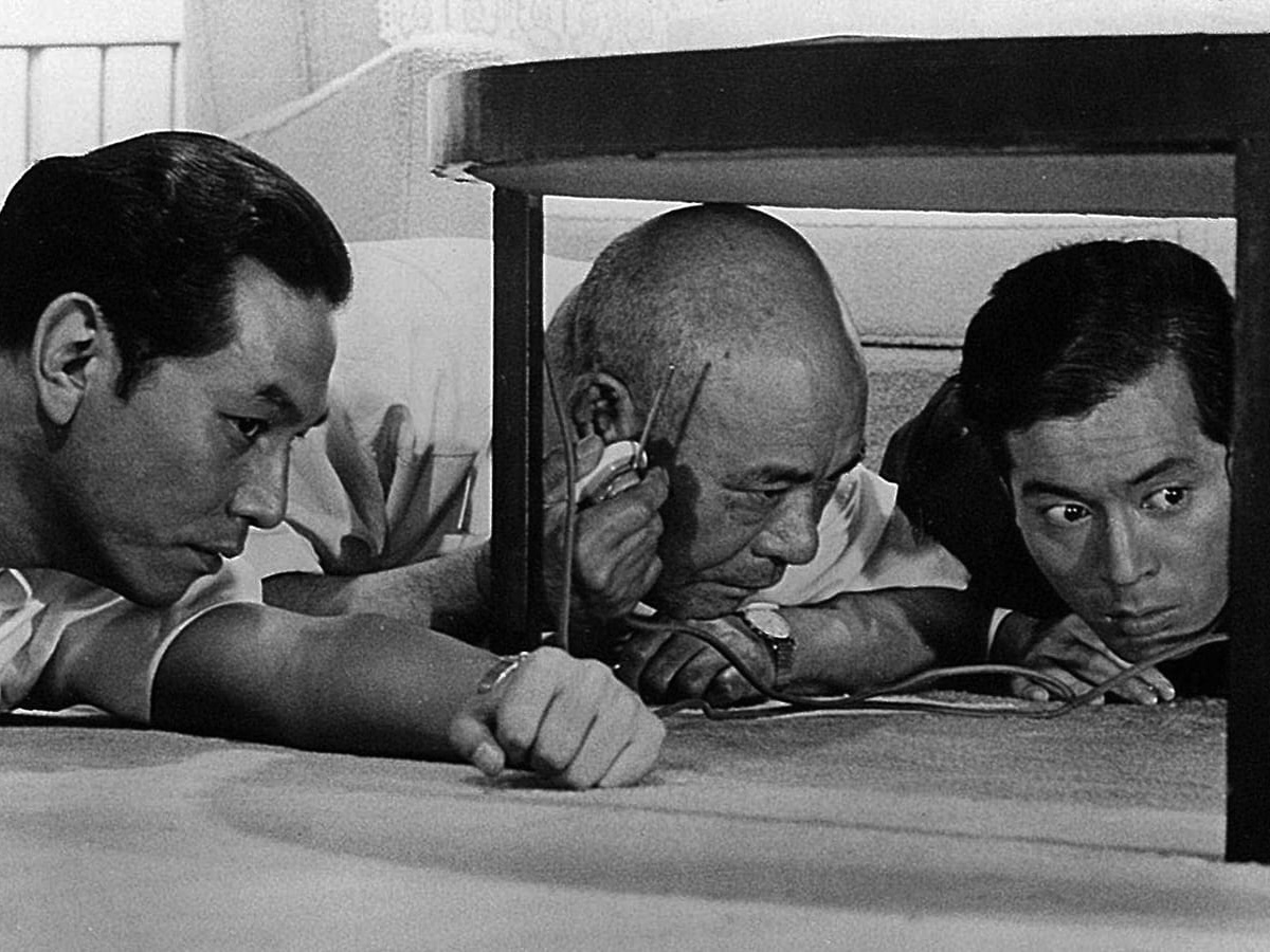 Scene from 'High and Low', where three men are hiding under a desk