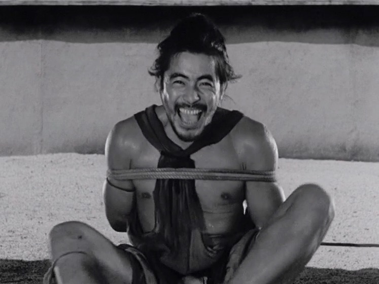 Scene from 'Rashomon', where a man is tied up and laughing