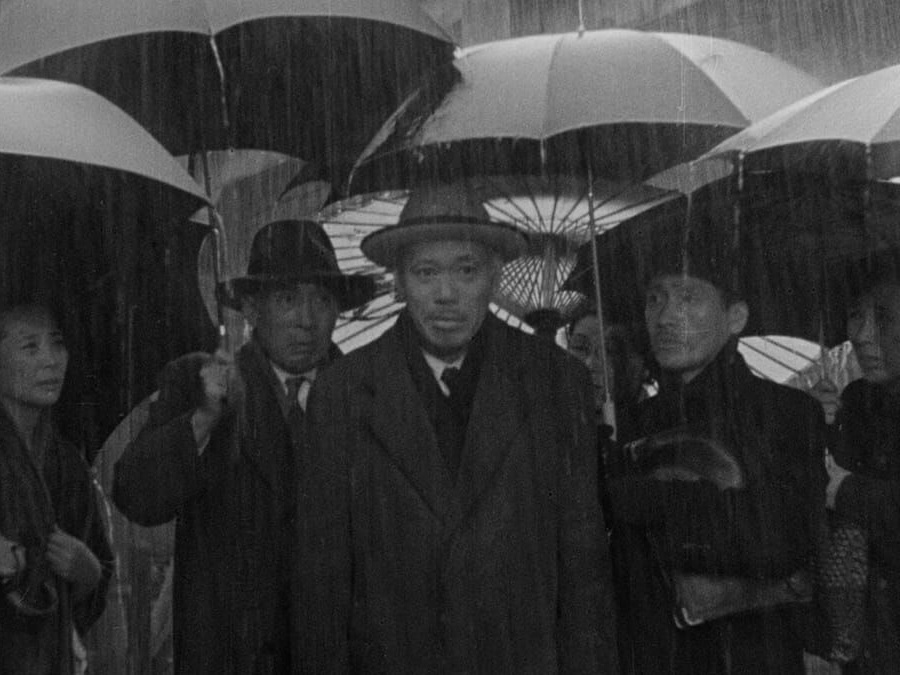 Scene from the movie 'Ikiru', 6 people in the rain with umbrellas