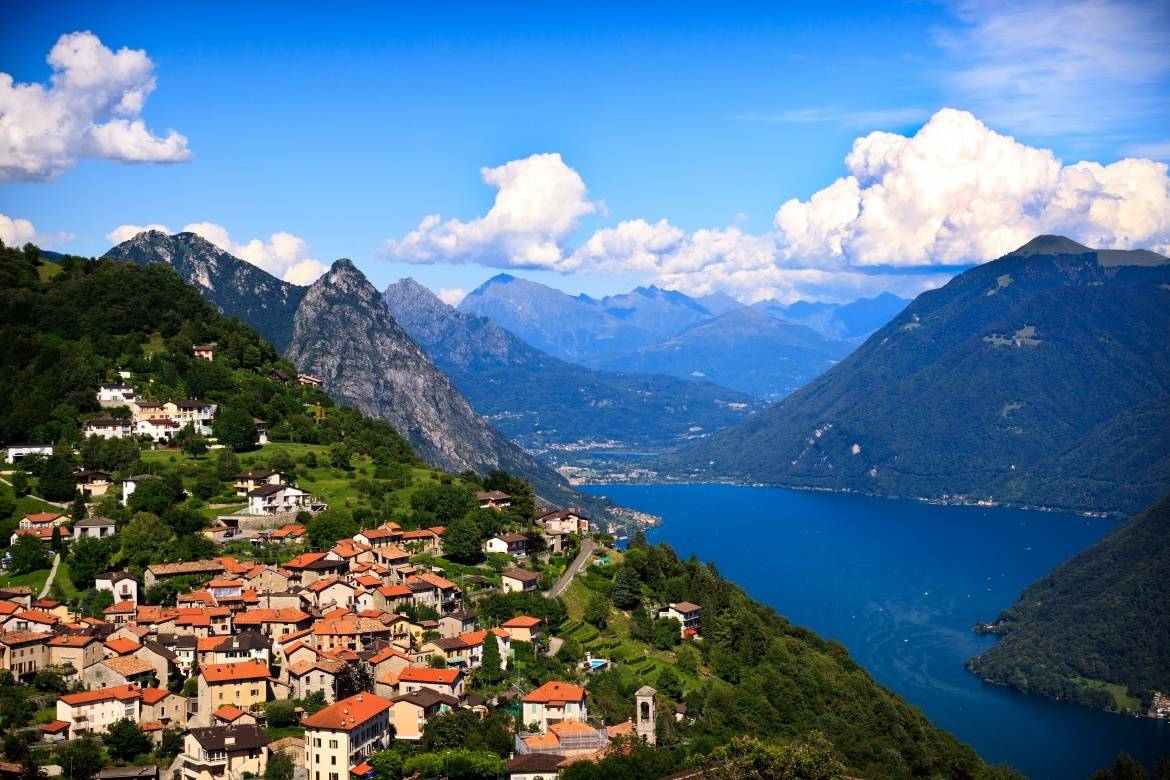 Lugano csodálatos város képe hegyekkel és tóval.